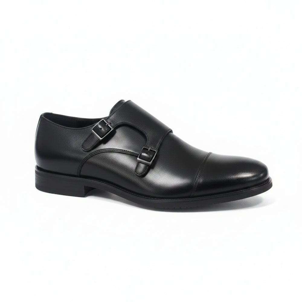 A single black leather double strap loafer shoe with a cap toe, shown from a side profile on a light gray reflective surface.