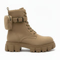 A single tan suede combat-style ankle boot with a chunky lug sole, lace-up front, side buckle strap, and a zippered pouch attached to the outer side, shown on a plain white background.