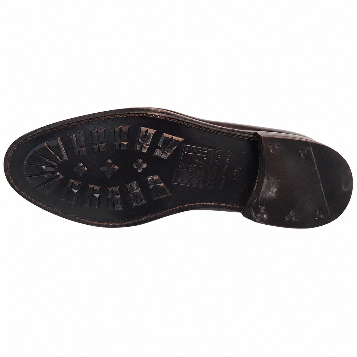Top-down view of a dark brown leather shoe sole, showing the tread pattern and heel block on a plain white background.