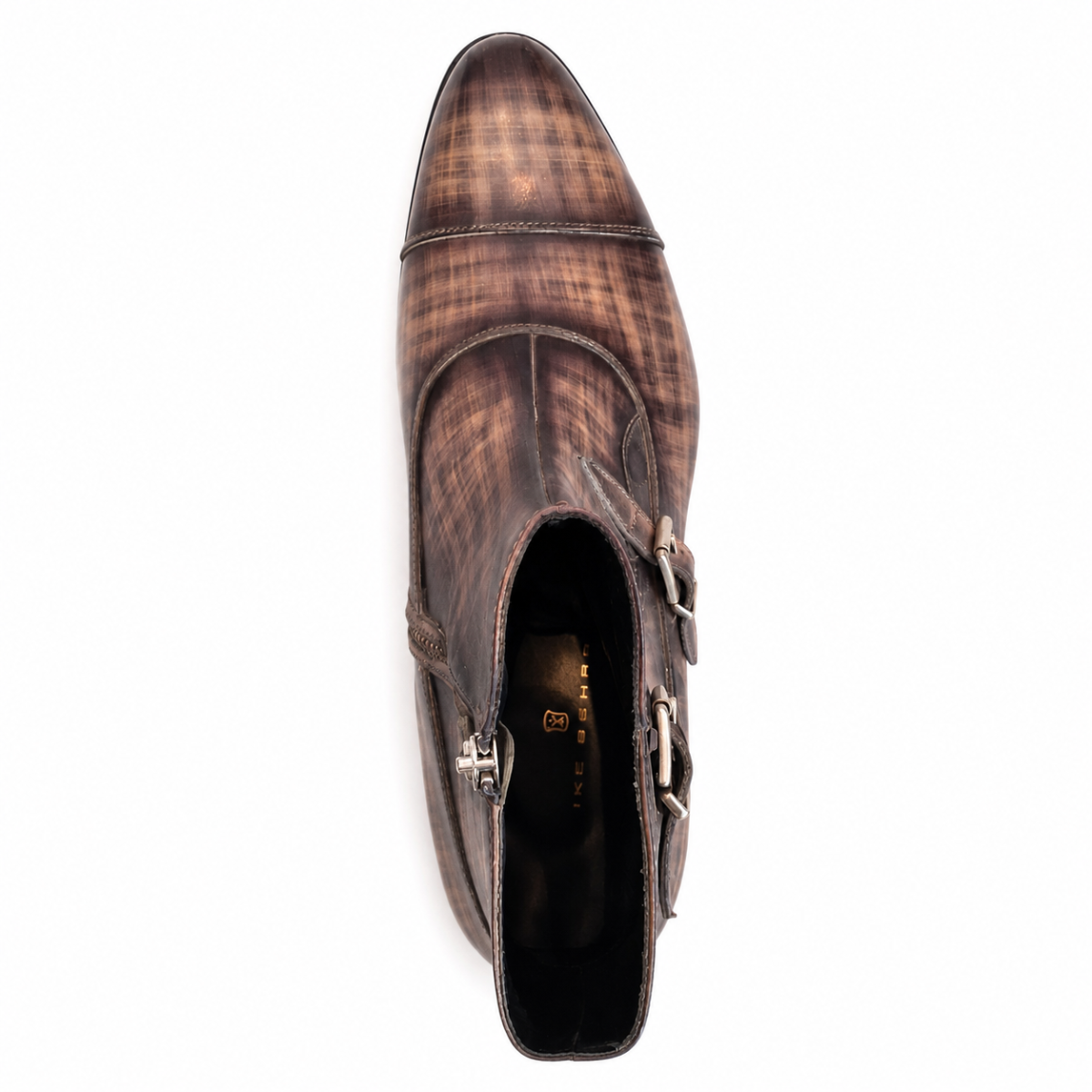 A single brown leather ankle boot with a distressed plaid pattern, featuring a cap toe, side buckle straps, and a heel zipper, shown from a top-down perspective on a white background.
