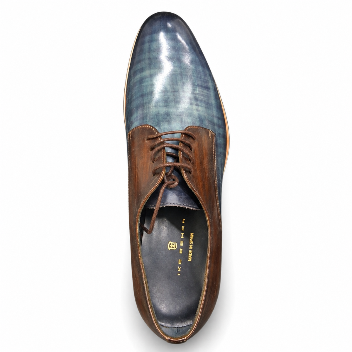 A men's oxford dress shoe shown from a top-down view on a white background. The shoe features a glossy blue-gray wood-grain patterned vamp and a smooth brown leather quarter panel with matching brown laces.