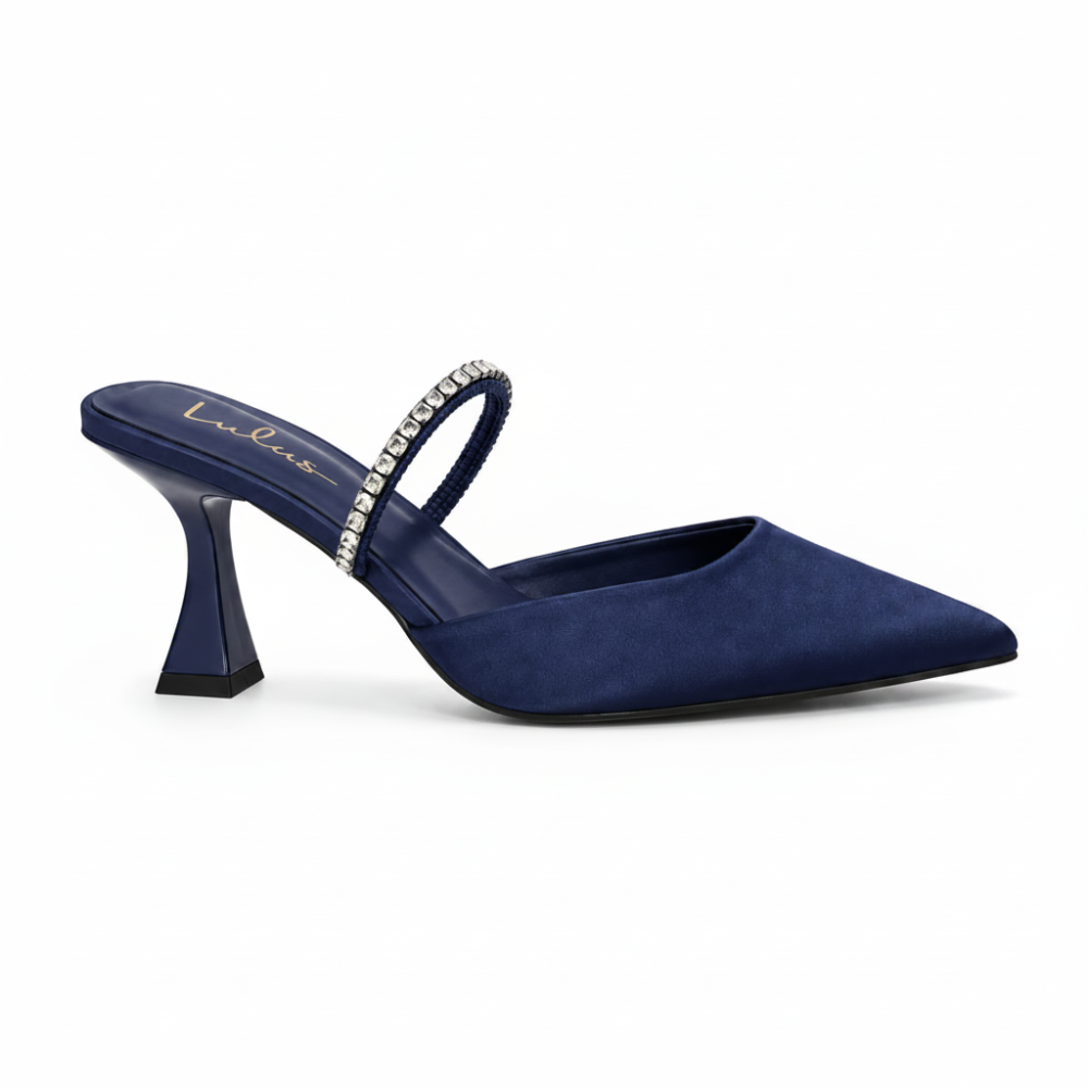 A navy blue suede pointed-toe mule heel with a rhinestone-embellished strap, shown from a side profile on a white background.