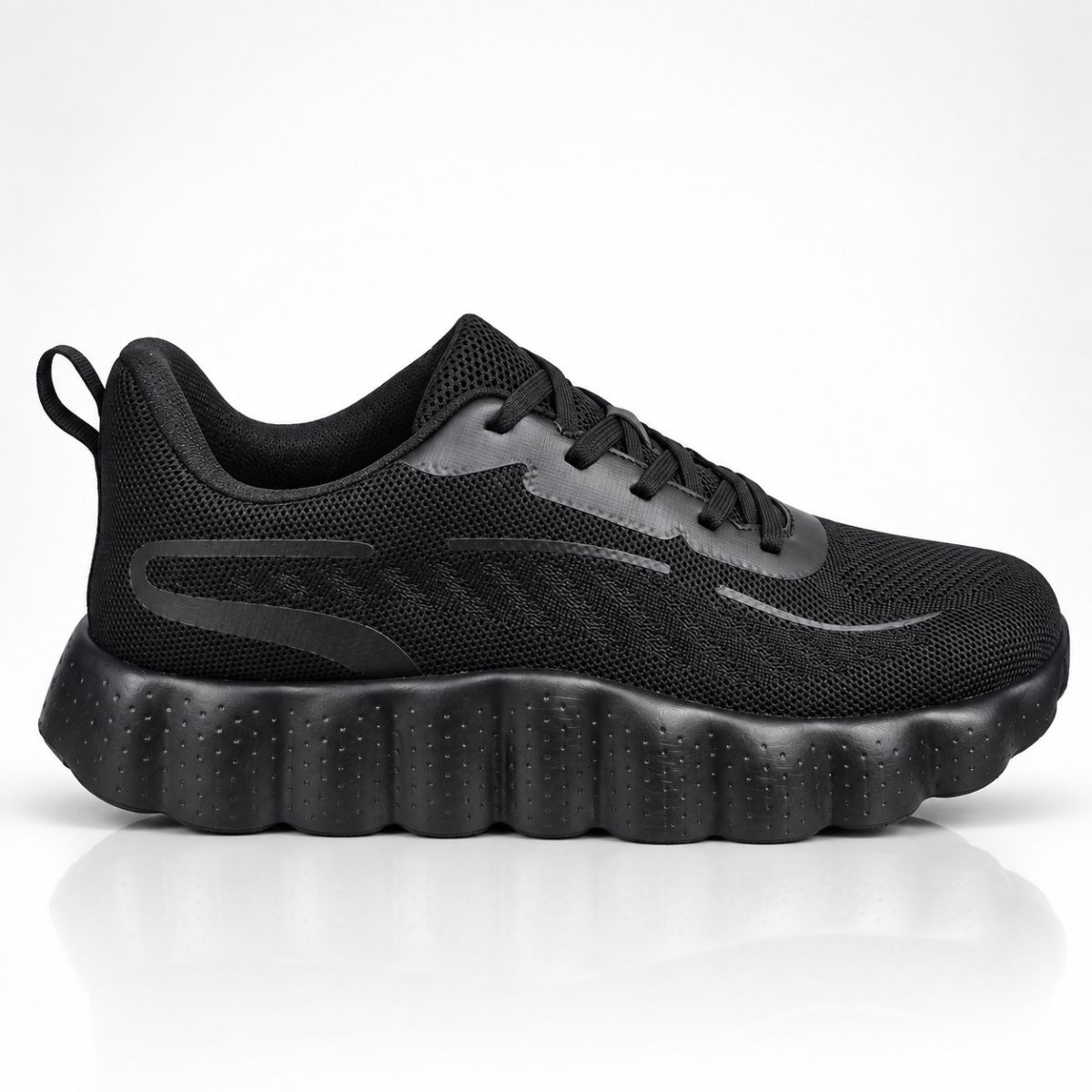 A black athletic sneaker with a textured mesh upper, black laces, and a chunky, wavy black sole, shown in a side profile on a white background with a soft reflection.