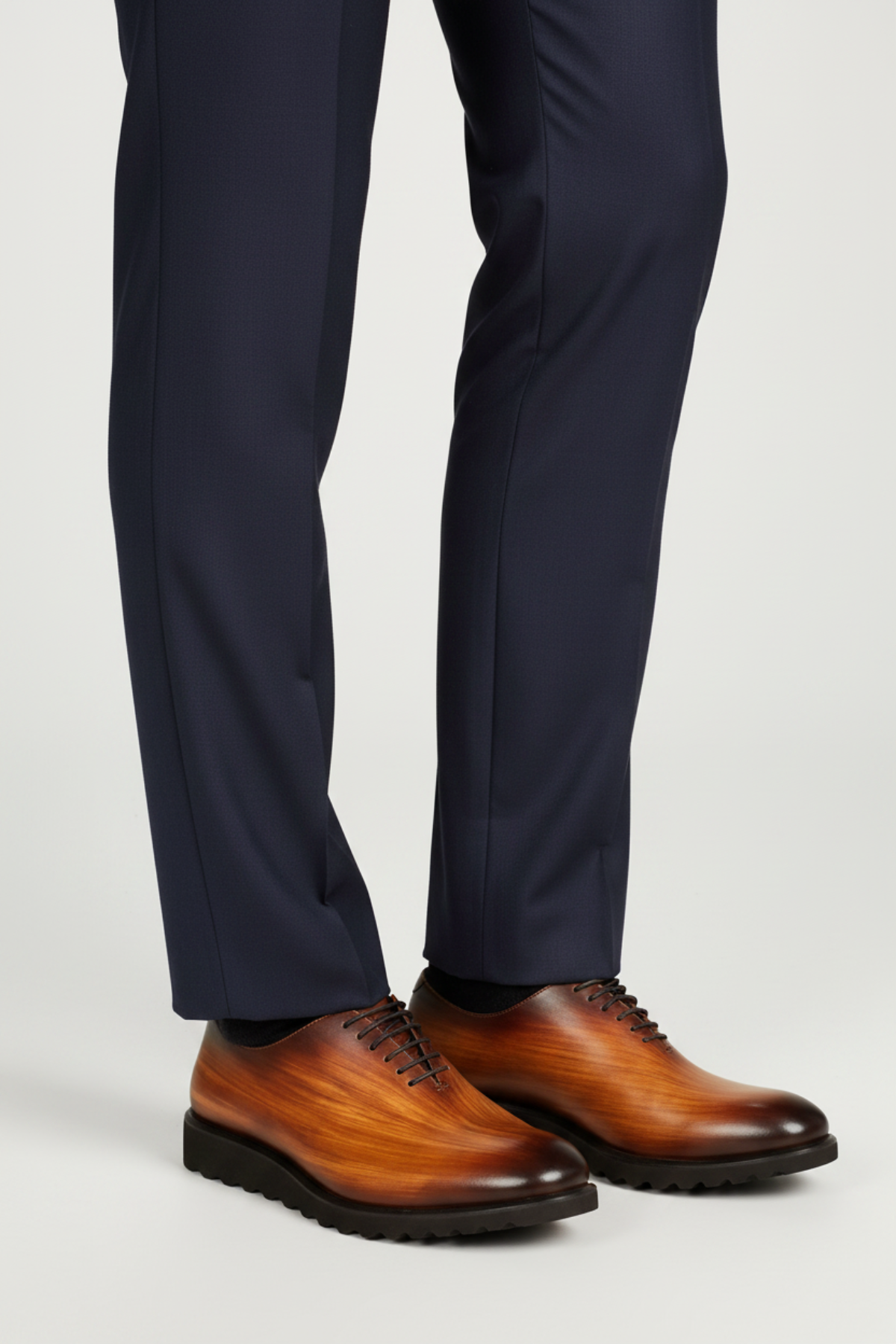 A man wearing a cognac leather shoe with a blue pant 