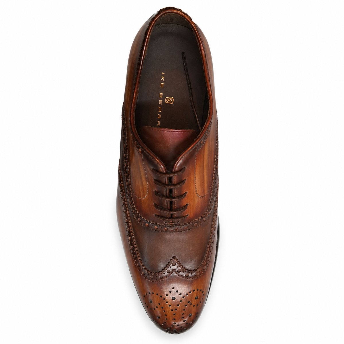 A single brown leather wingtip oxford shoe shown from a top-down view on a plain white background. The shoe features decorative brogue perforations, a pointed toe, and a dark brown insole with gold branding text that reads 'TED BARRA'.