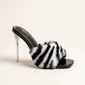 Women's zebra print faux fur mule heels with clear stiletto heel and black patent footbed, side view