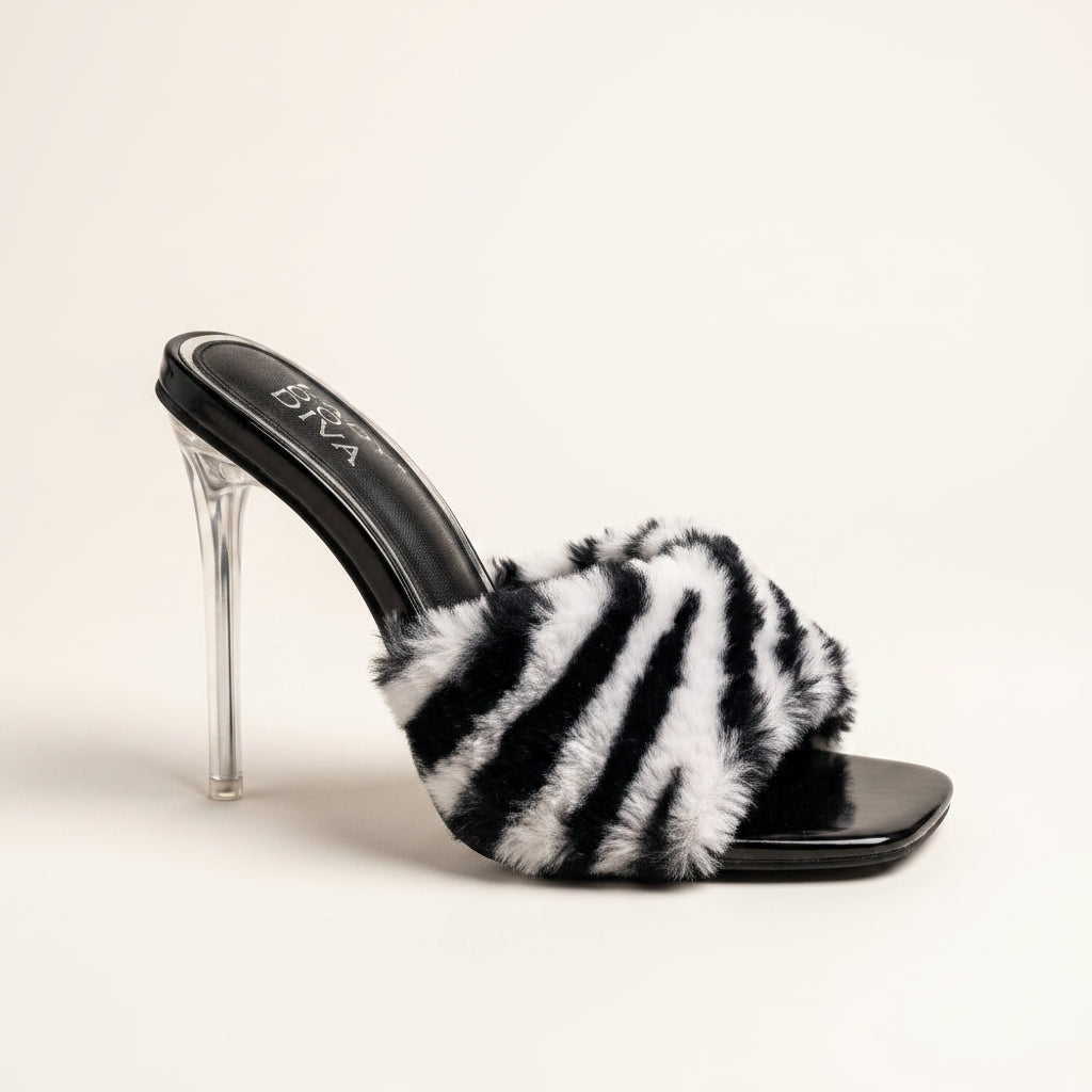 Women's zebra print faux fur mule heels with clear stiletto heel and black patent footbed, side view