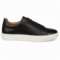 A classic low-top leather sneaker in a Black color , featuring dark brown laces and a thick, chunky off-white rubber sole, shown from a side profile on a white background.