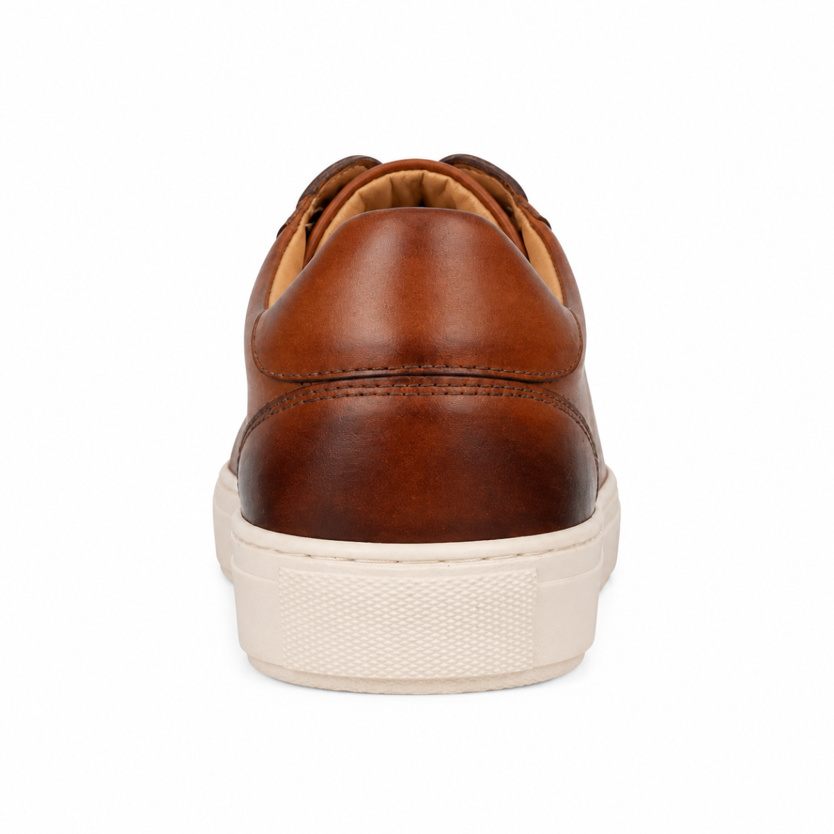 A single brown leather sneaker shown from a rear three-quarter view, featuring a warm brown leather upper with decorative stitching and a thick, textured off-white rubber sole.